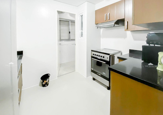 semi-furnished corner condo boasts a spacious balcony and a bedroom